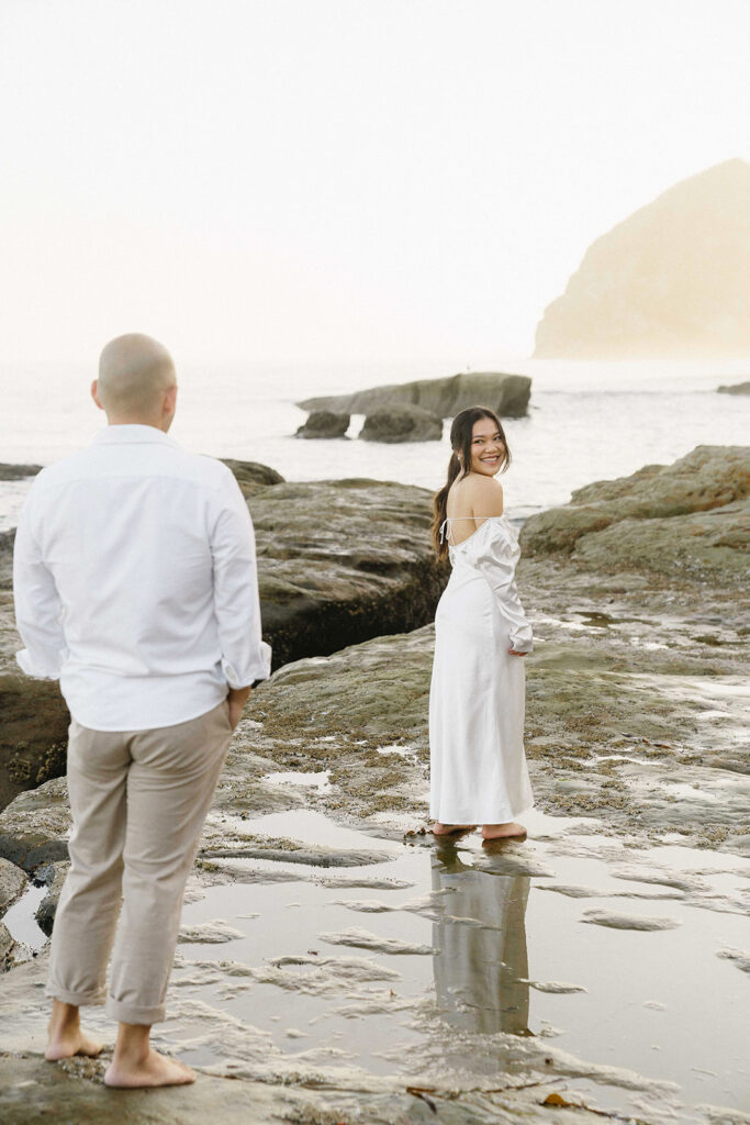 playful engagement photos for couples on the beach in cape kiwanda

