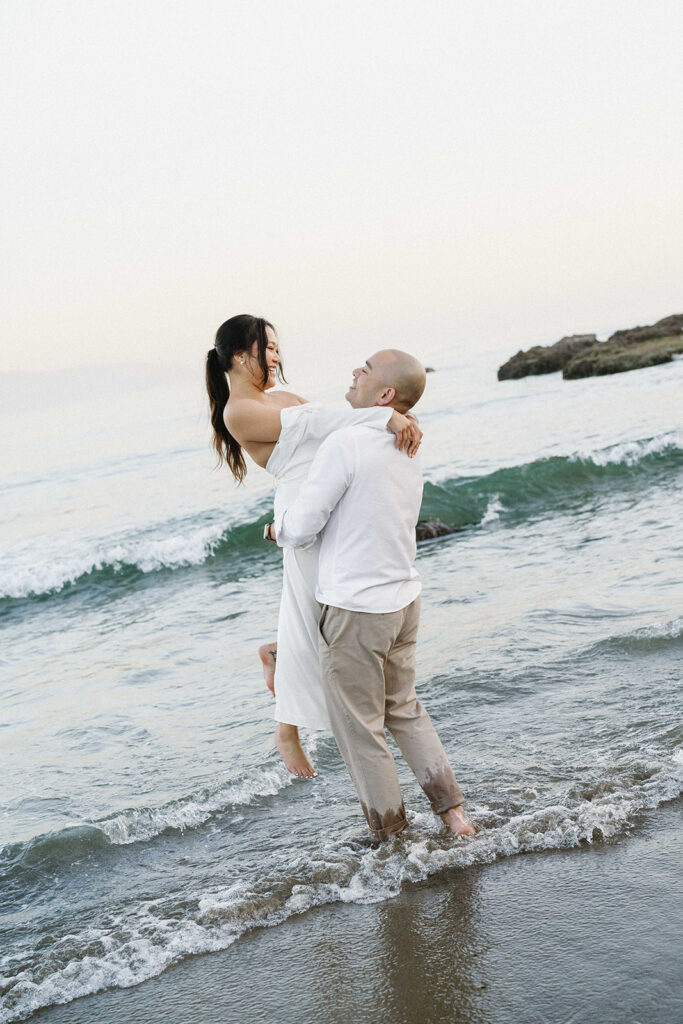 playful engagement photos for couples on the beach in cape kiwanda

