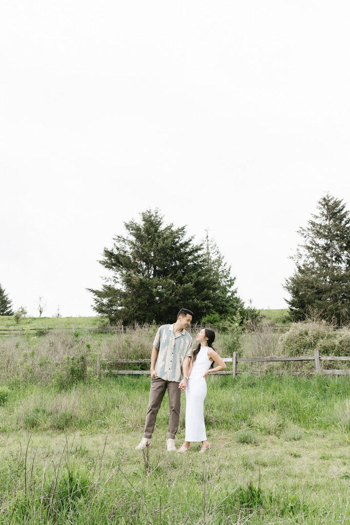 couple posing in a field for their engagement shoot
