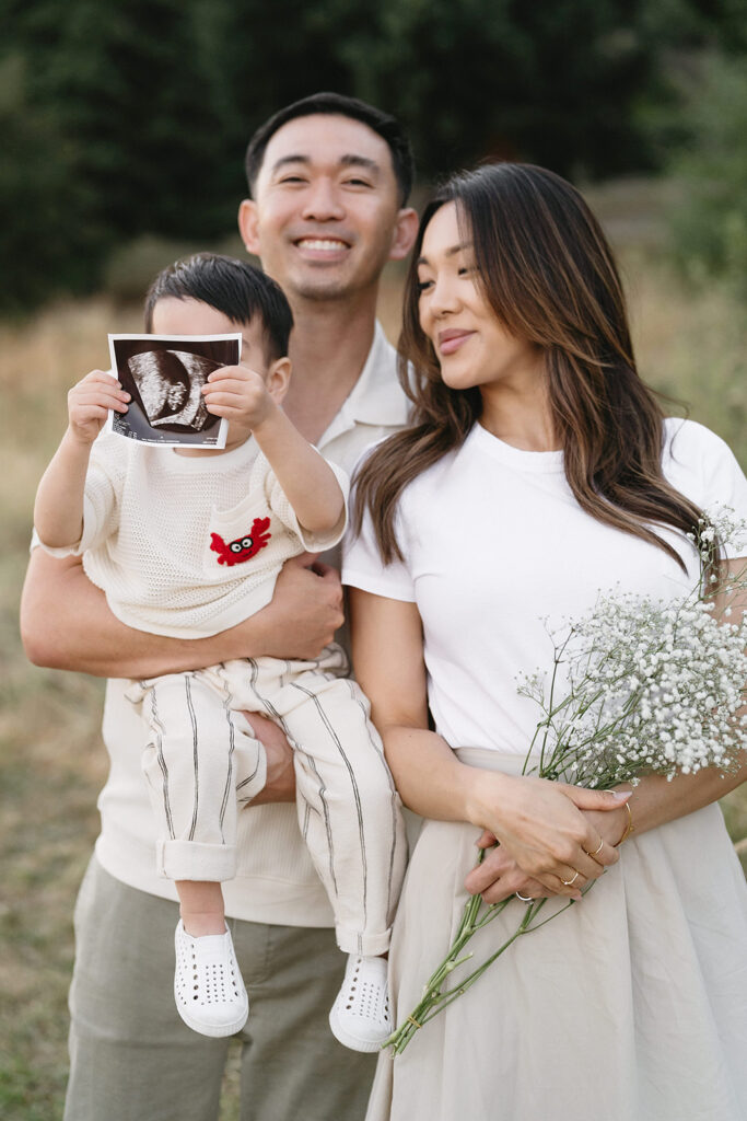 family taking photos in a field
