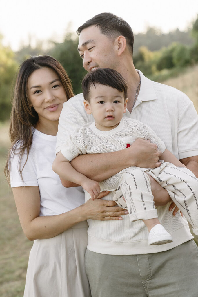 mom and dad posing with their son
