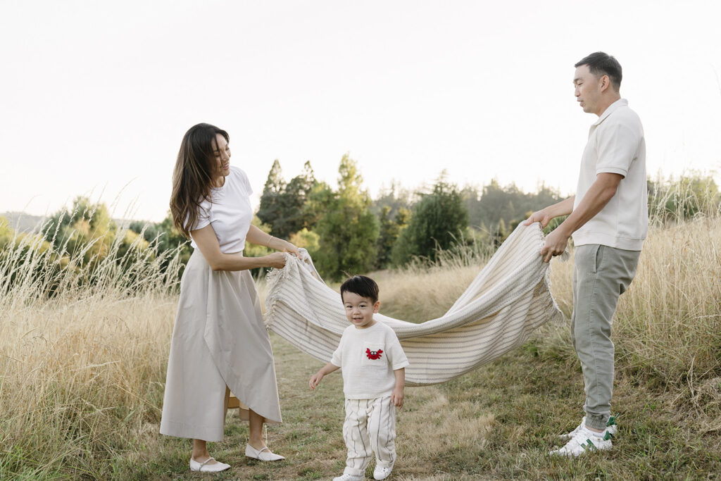 family taking photos in a field
