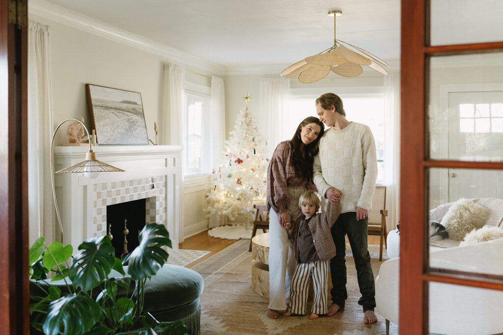 A family of three enjoying a candid moment during their in-home photo session in Portland.
