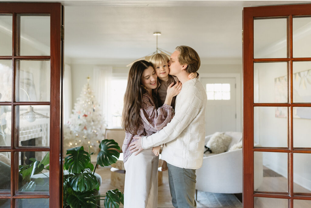 A family of three enjoying a candid moment during their in-home photo session in Portland.
