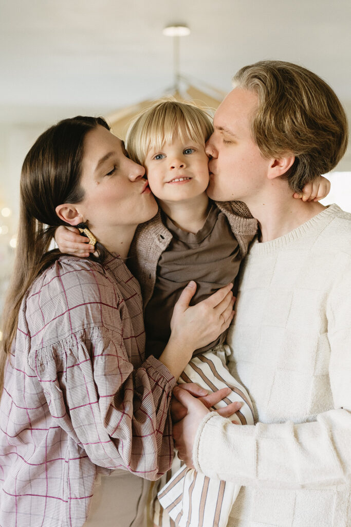 A family of three enjoying a candid moment during their in-home photo session in Portland.
