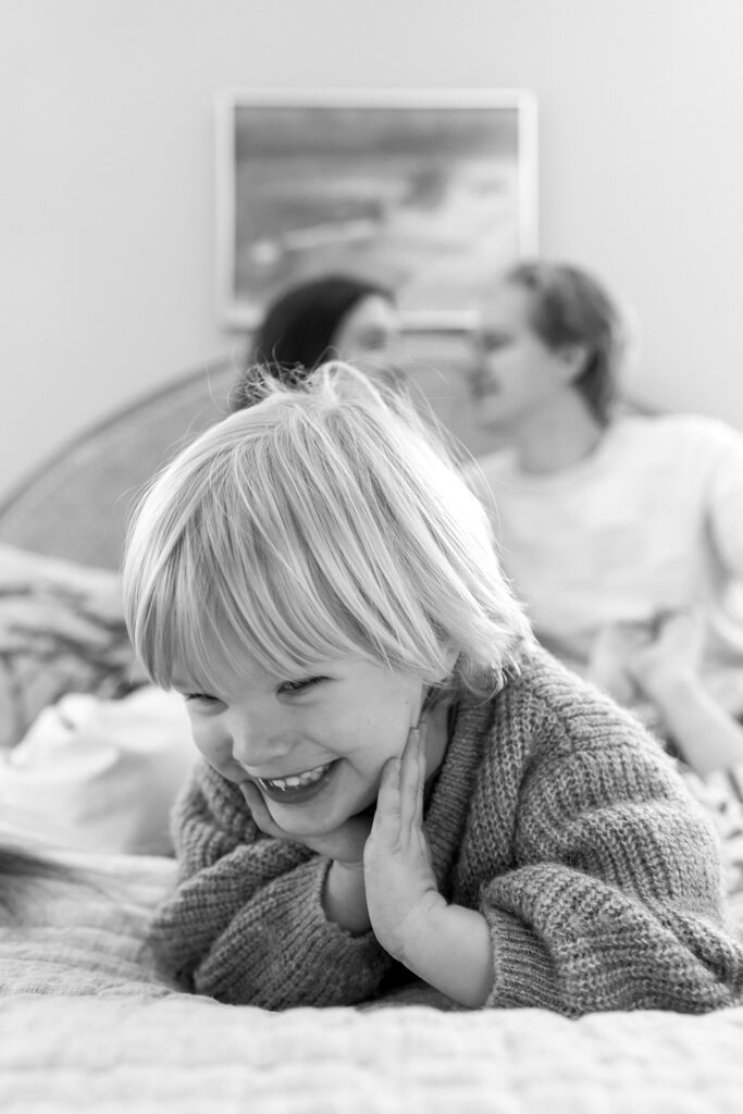 A family of three enjoying a candid moment during their in-home photo session in Portland.
