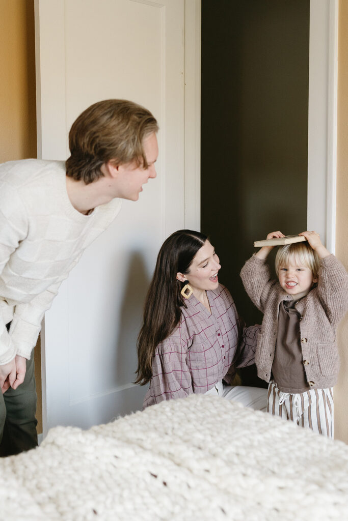 A family of three enjoying a candid moment during their in-home photo session in Portland.
