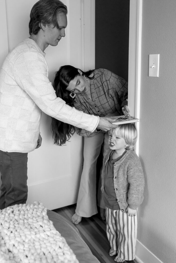 A family of three enjoying a candid moment during their in-home photo session in Portland.
