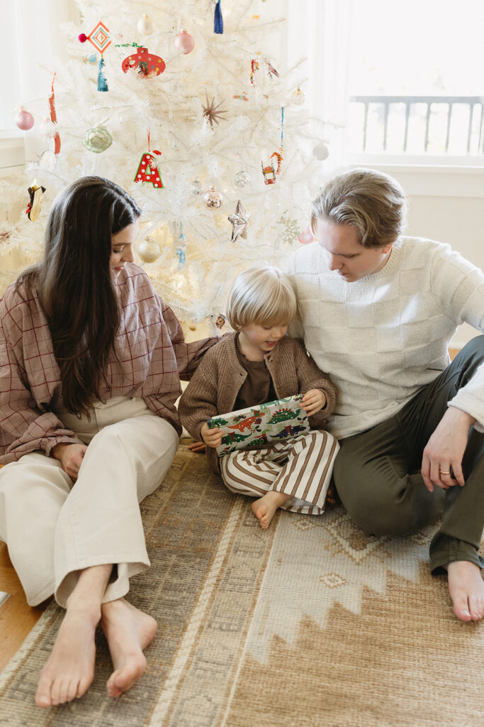 A family of three enjoying a candid moment during their in-home photo session in Portland.
