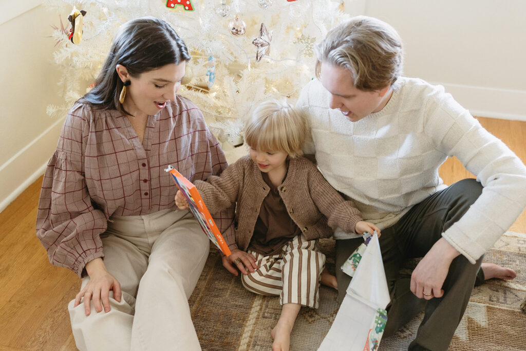 A family of three enjoying a candid moment during their in-home photo session in Portland.
