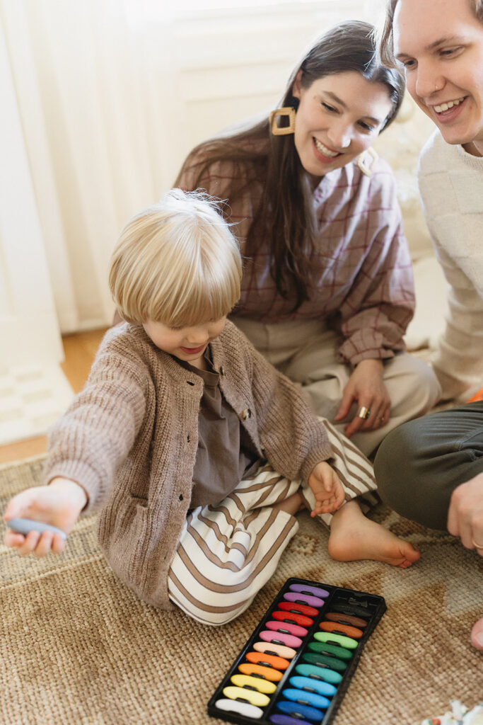 A family of three enjoying a candid moment during their in-home photo session in Portland.
