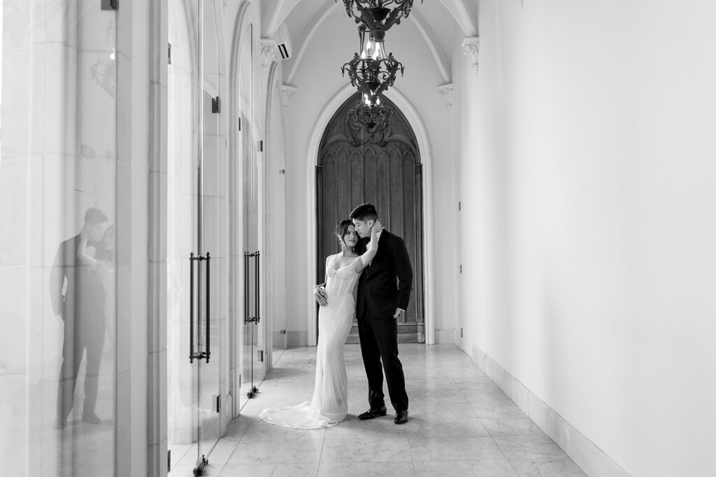 Bride and groom pose in front of The Chauteau Nouvelle in Houston, Texas, surrounded by elegant architecture before their wedding.
