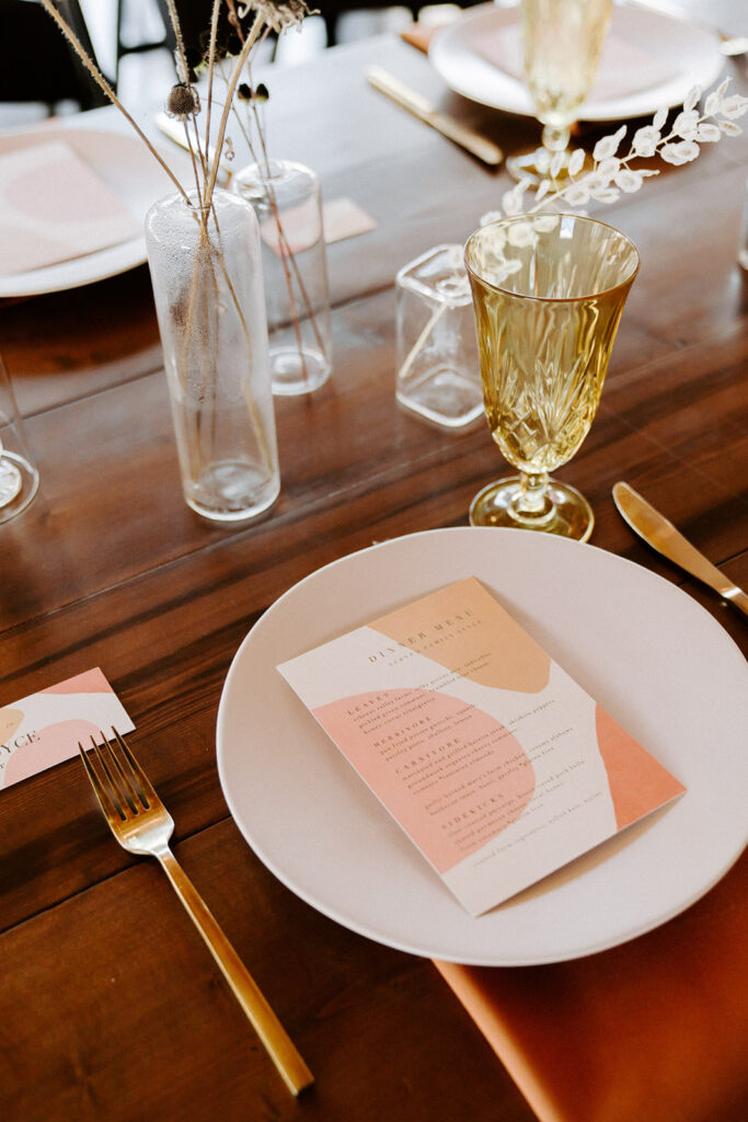 tablescape design of colorful menus and gold accents