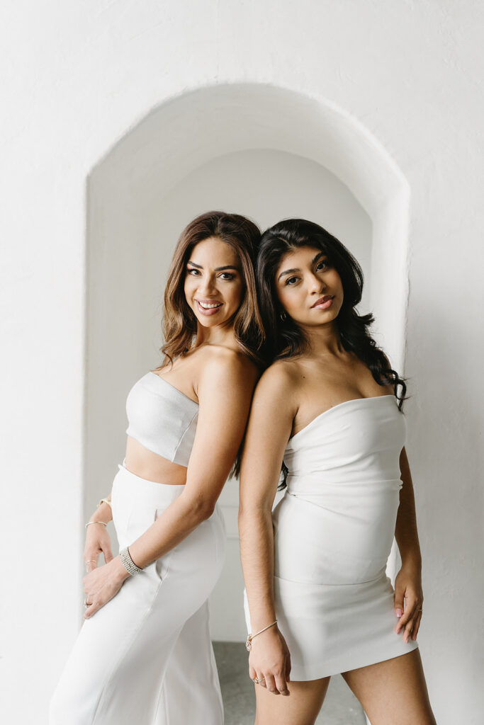 Mother and daughter posing together during a fun and fashionable photoshoot in a studio
