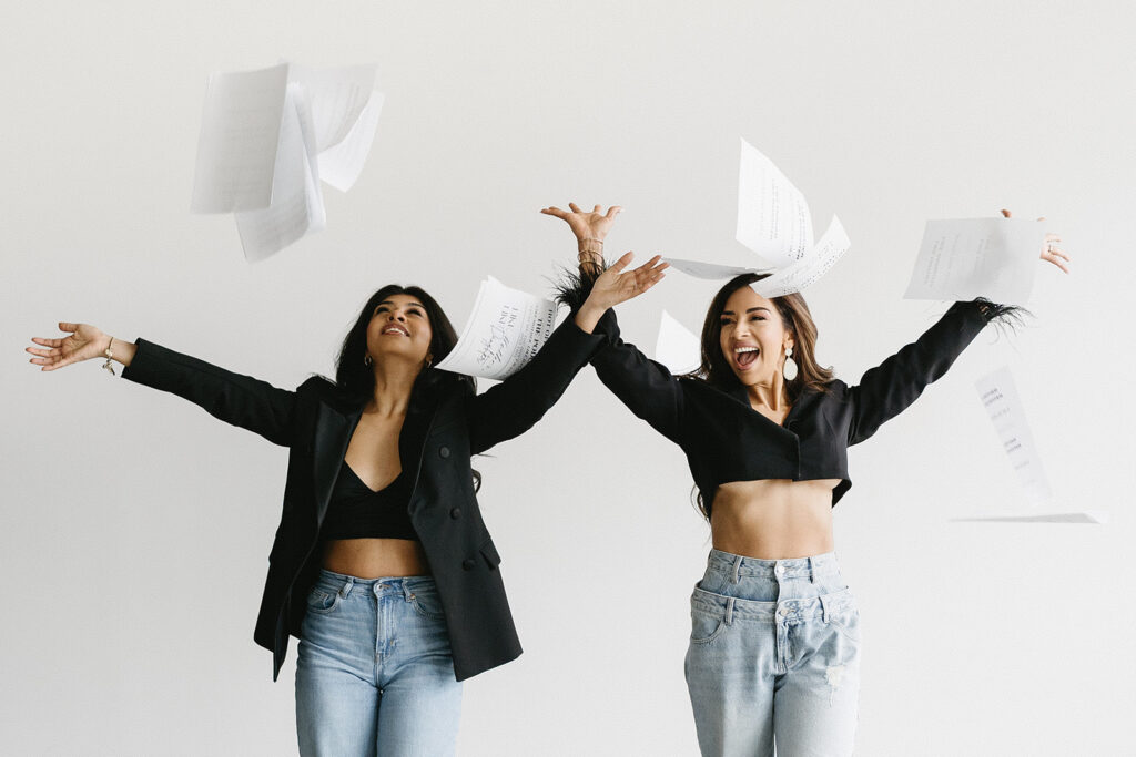 Mother and daughter posing together during a fun and fashionable photoshoot in a studio
