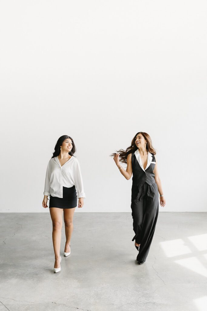 Mother and daughter posing together during a fun and fashionable photoshoot in a studio
