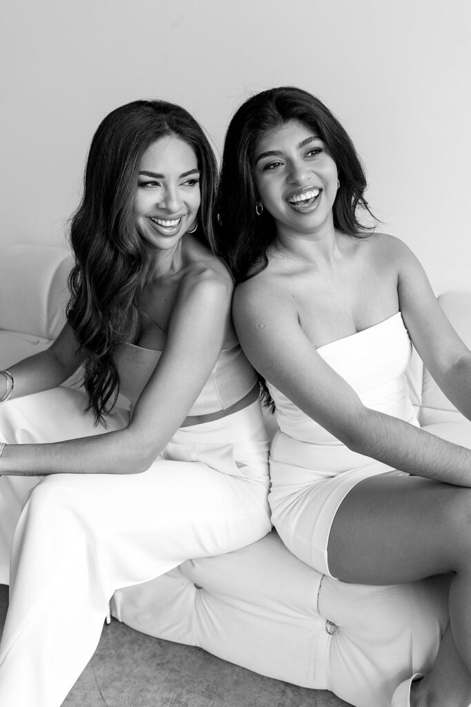 Mother and daughter posing together during a fun and fashionable photoshoot in a studio
