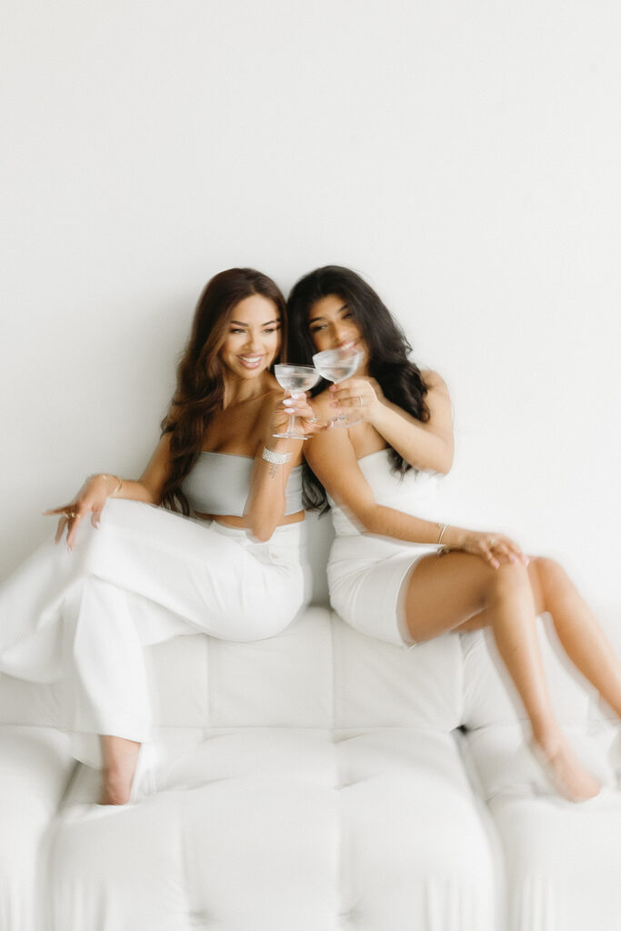 Mother and daughter posing together during a fun and fashionable photoshoot in a studio
