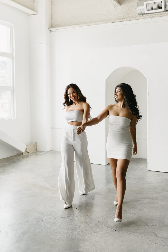 Mother and daughter posing together during a fun and fashionable photoshoot in a studio
