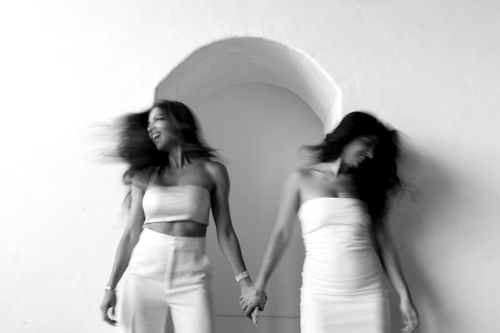 Mother and daughter posing together during a fun and fashionable photoshoot in a studio
