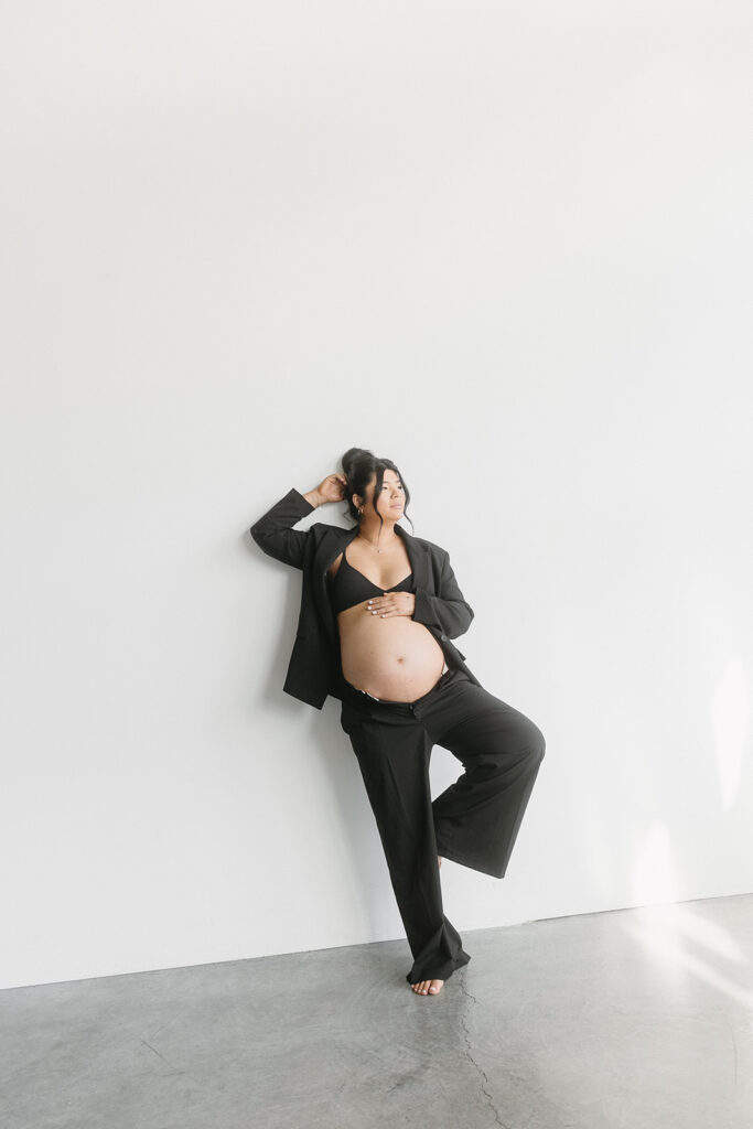 Studio maternity photo of expecting mother with soft draping and neutral tones
