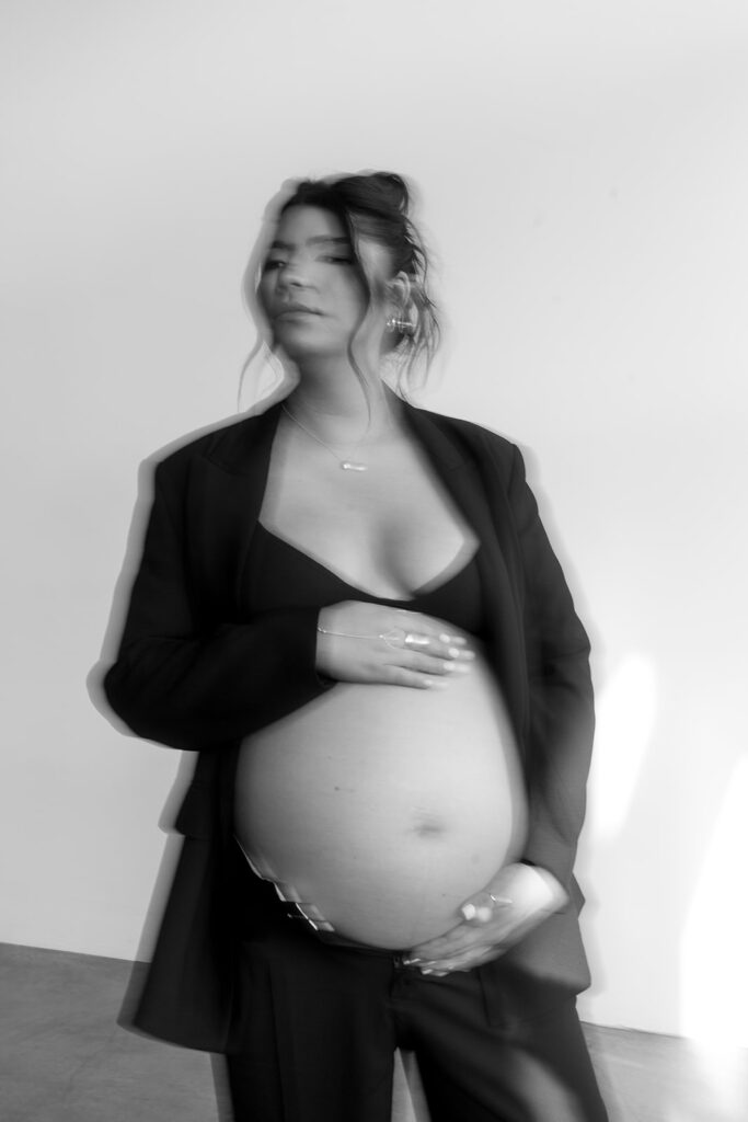 Minimalist maternity portrait with floral accents in natural light
