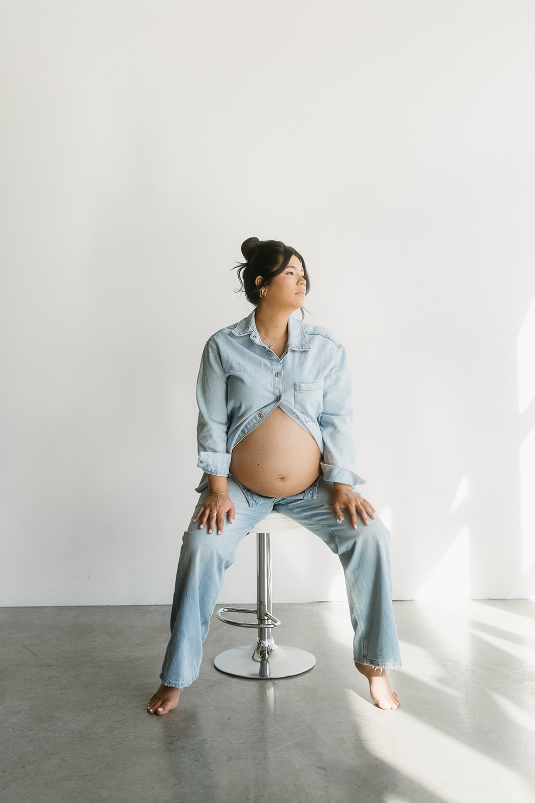 Studio maternity photo of expecting mother with soft draping and neutral tones