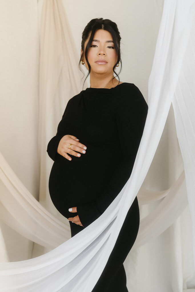 Minimalist maternity portrait with floral accents in natural light
