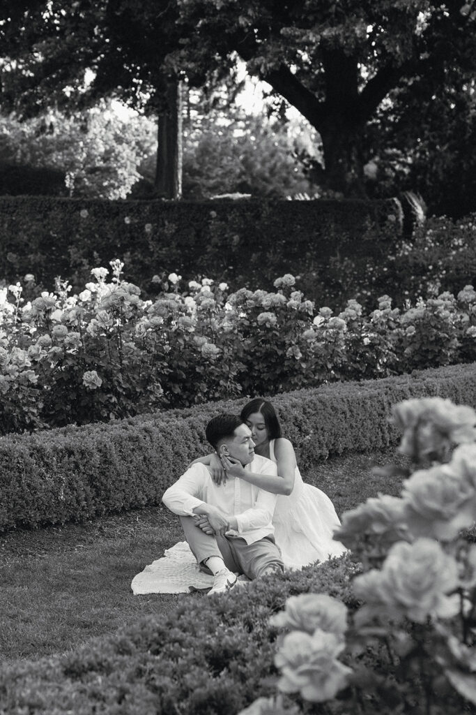 Candid moment of a couple laughing together in a peaceful garden.
