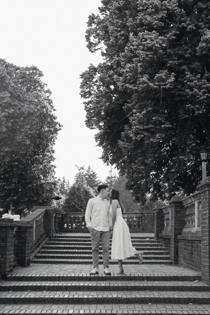 A couple walking through a blooming rose garden during their engagement session | Peninsula Rose Garden
