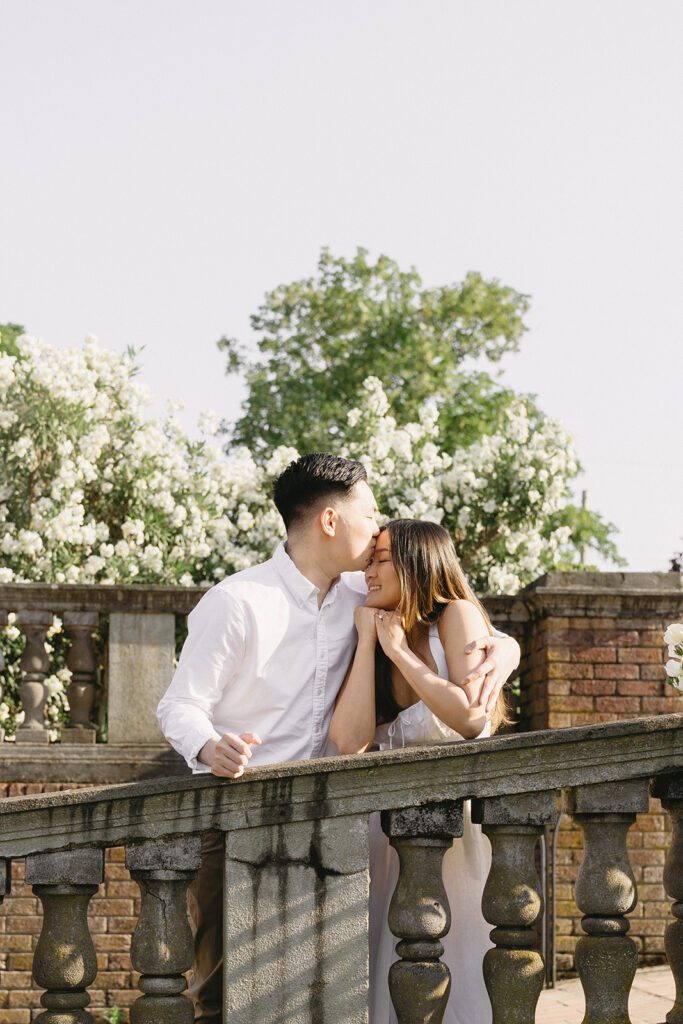 A couple walking through a blooming rose garden during their engagement session | Peninsula Rose Garden
