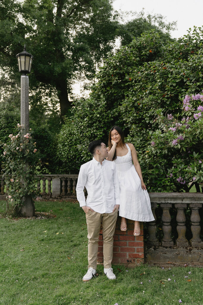 A couple walking through a blooming rose garden during their engagement session | Peninsula Rose Garden
