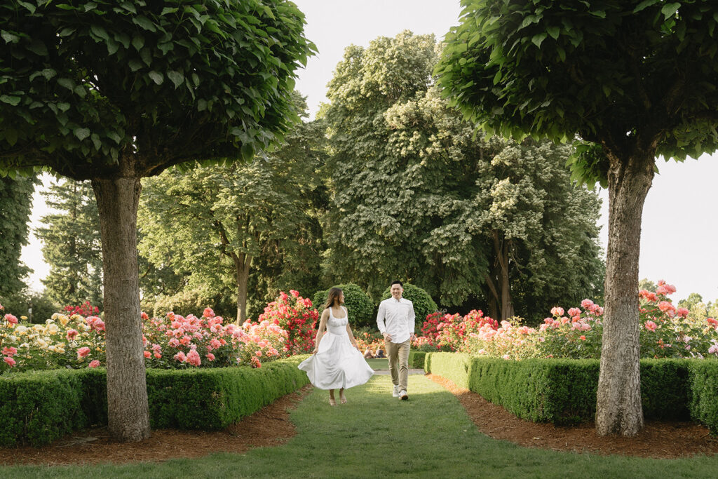 Romantic engagement photo of a couple surrounded by colorful flowers.
