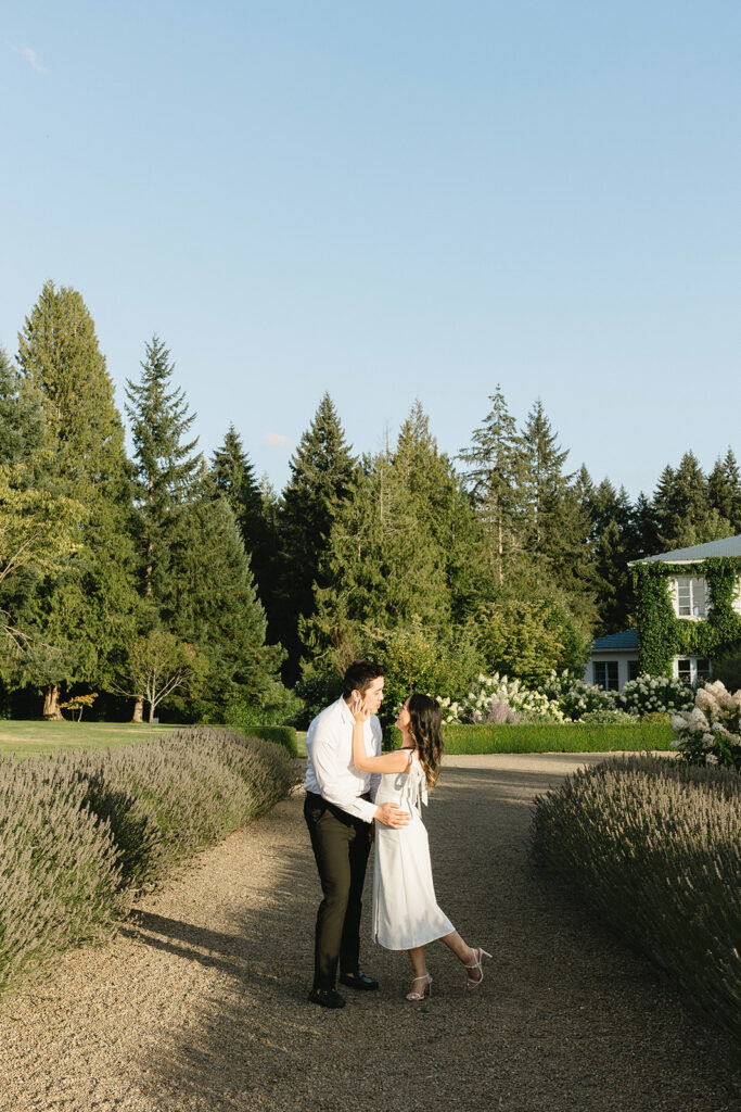 Couple exploring vineyard paths and stone archways during engagement shoot
