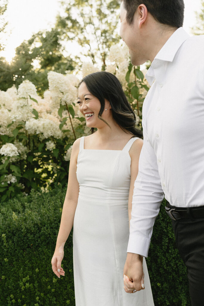 Couple exploring vineyard paths and stone archways during engagement shoot
