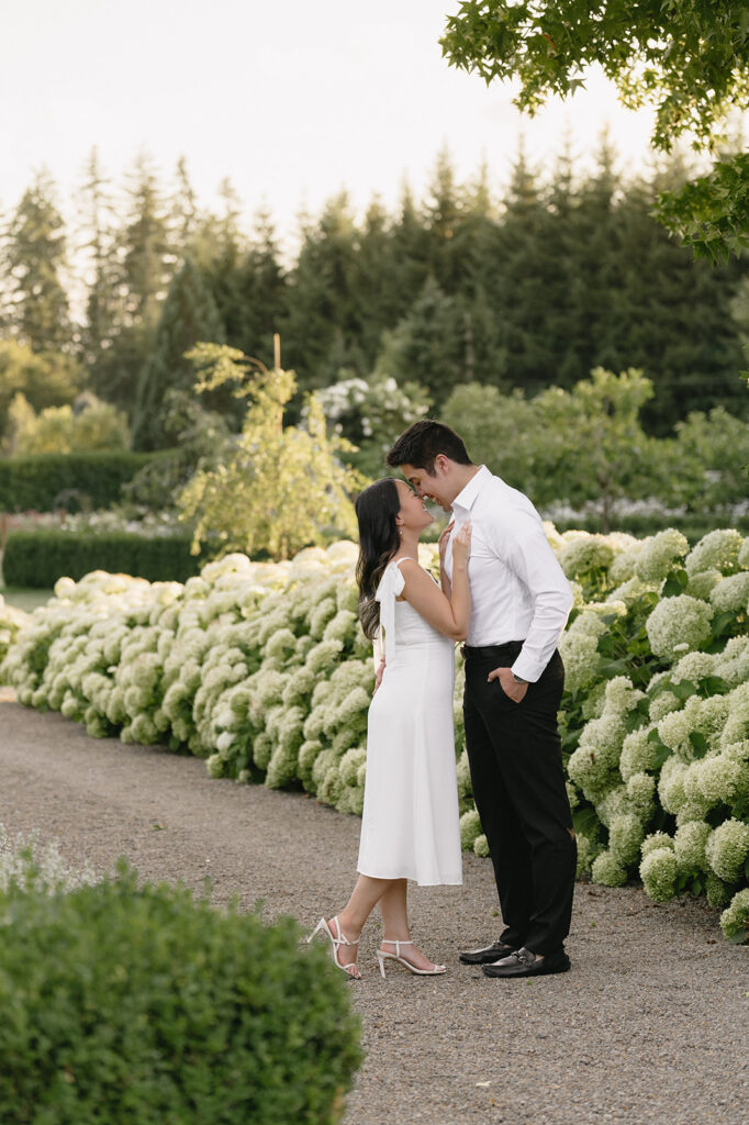 Couple exploring vineyard paths and stone archways during engagement shoot
