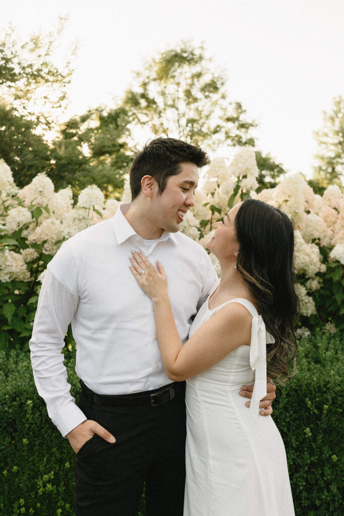 Natural candid engagement photo in a romantic garden setting
