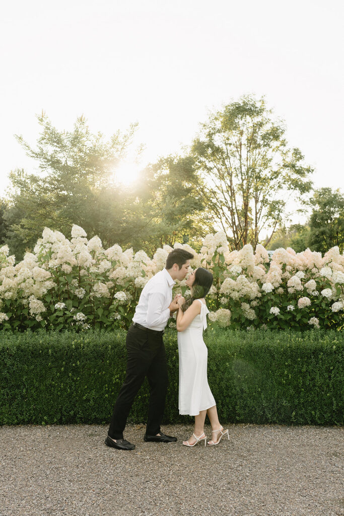 Natural candid engagement photo in a romantic garden setting

