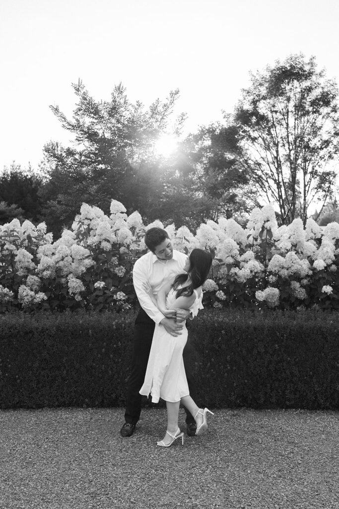 Natural candid engagement photo in a romantic garden setting
