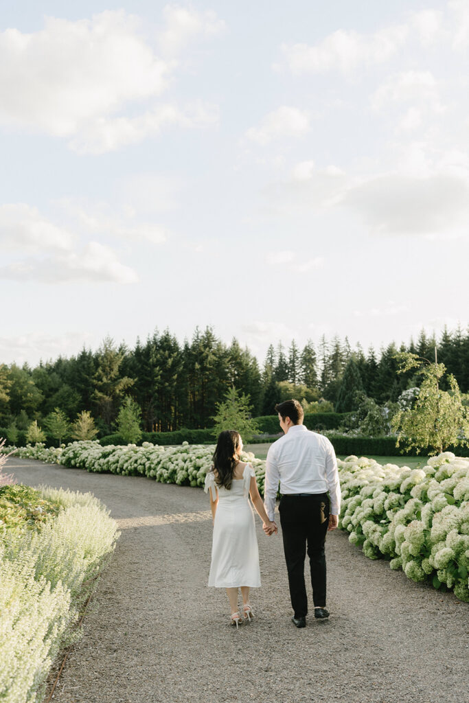 Couple walking through the gardens at during their engagement session
