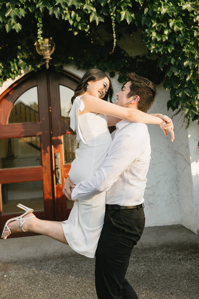 Couple walking through the gardens at Monet Vineyard during their engagement session
