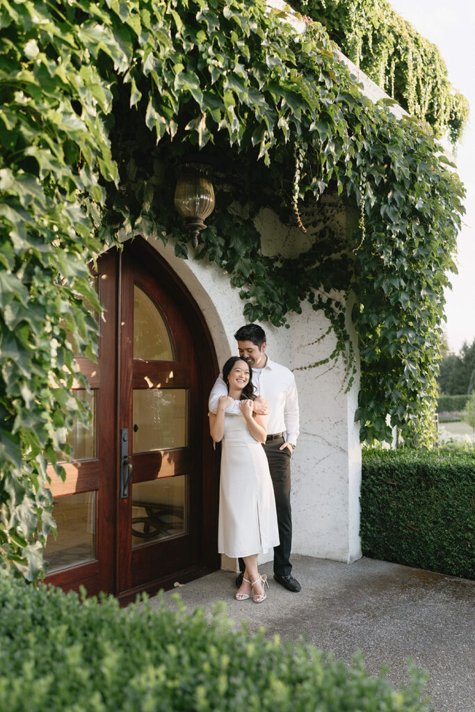 Couple walking through the gardens at Monet Vineyard during their engagement session
