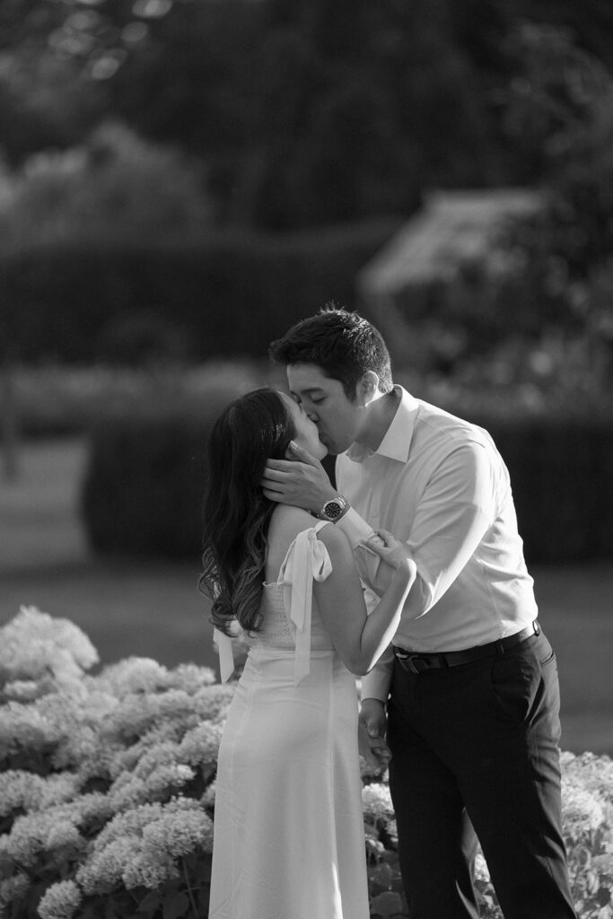 Couple exploring vineyard paths and stone archways during engagement shoot
