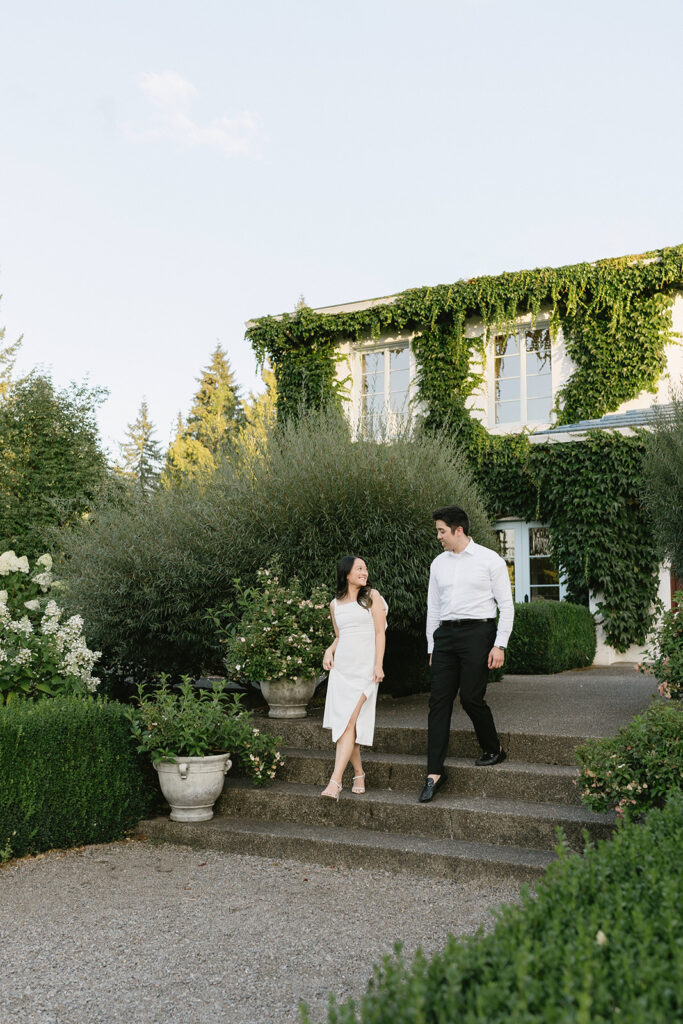 Couple walking through the gardens at Monet Vineyard during their engagement session
