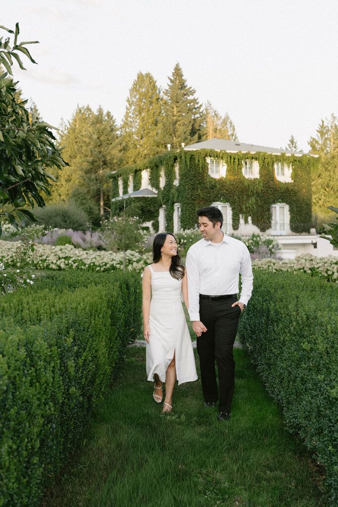 Romantic engagement photo surrounded by blooming hydrangeas at a vineyard estate
