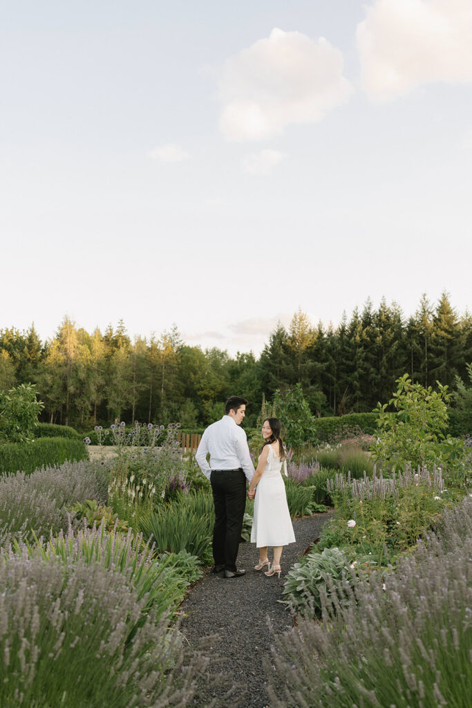 Romantic engagement photo surrounded by blooming hydrangeas at a vineyard estate

