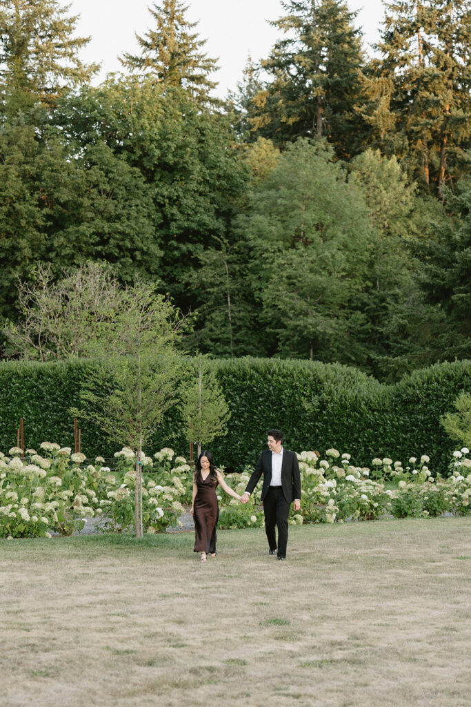 Couple walking through the gardens at during their engagement session
