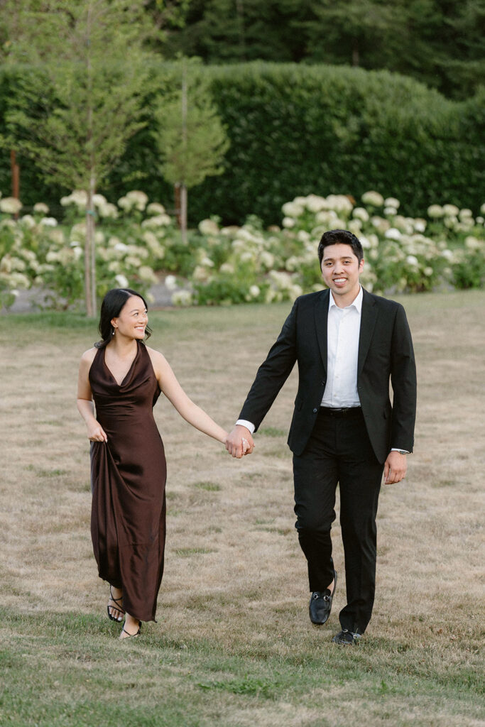 Romantic engagement photo surrounded by blooming hydrangeas at a vineyard estate
