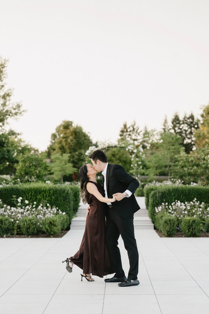Romantic engagement photo surrounded by blooming hydrangeas at a vineyard estate
