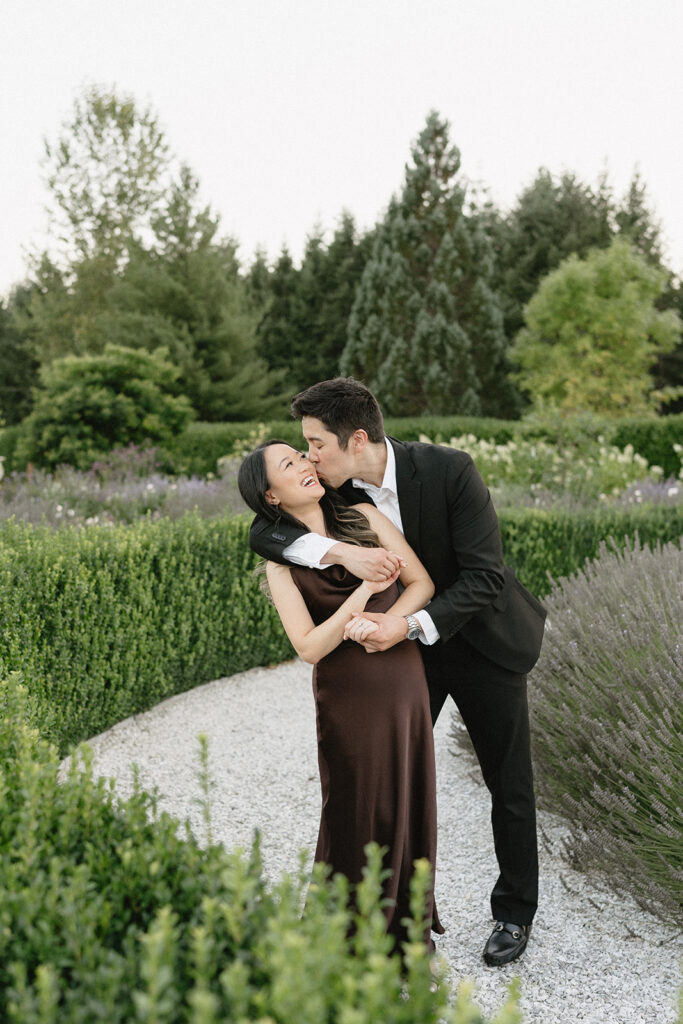 Romantic engagement photo surrounded by blooming hydrangeas at a vineyard estate
